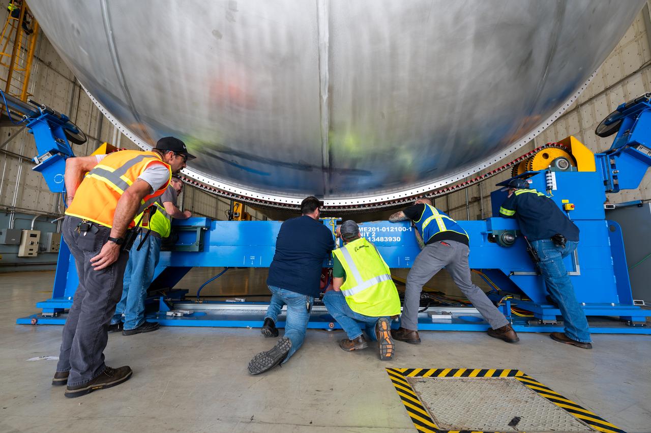 The core stage liquid hydrogen tank for the Artemis III mission completed proof testing, and technicians returned it to the main factory building at NASA’s Michoud Assembly Facility in New Orleans where it will undergo more outfitting. As part of proof testing, technicians apply a simple soap solution and check for leaks by observing any bubble formation on the welds. The technician removed the bubble solution with distilled water and then dried the area of application to prevent corrosion. To build the Space Launch System (SLS) rocket’s 130-foot core stage liquid hydrogen tank, engineers use robotic tools to weld five-barrel segments. This process results in a tank with around 1,900 feet, or more than six football fields, of welds that must be tested by hand. After the leak tests, the core stage lead, Boeing, pressurized the SLS tank to further ensure there were no leaks. After it passed proof testing, technicians moved the Artemis III liquid hydrogen tank to Michoud’s main factory. Soon, the technicians will prime and apply a foam-based thermal protection system that protects the tank during launch. Later, the tank will be joined with other parts of the core stage to form the entire 212-foot rocket stage with its four RS-25 engines that produce 2 million pounds of thrust to help launch the rocket. Artemis III will land the first astronauts on the lunar surface.